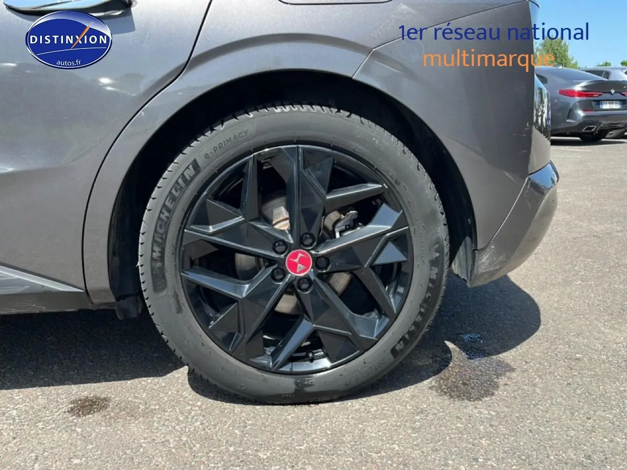 Gros plan sur la roue arrière droite noire avec jante design du DS4 gris platinium 2023 E-tense.
