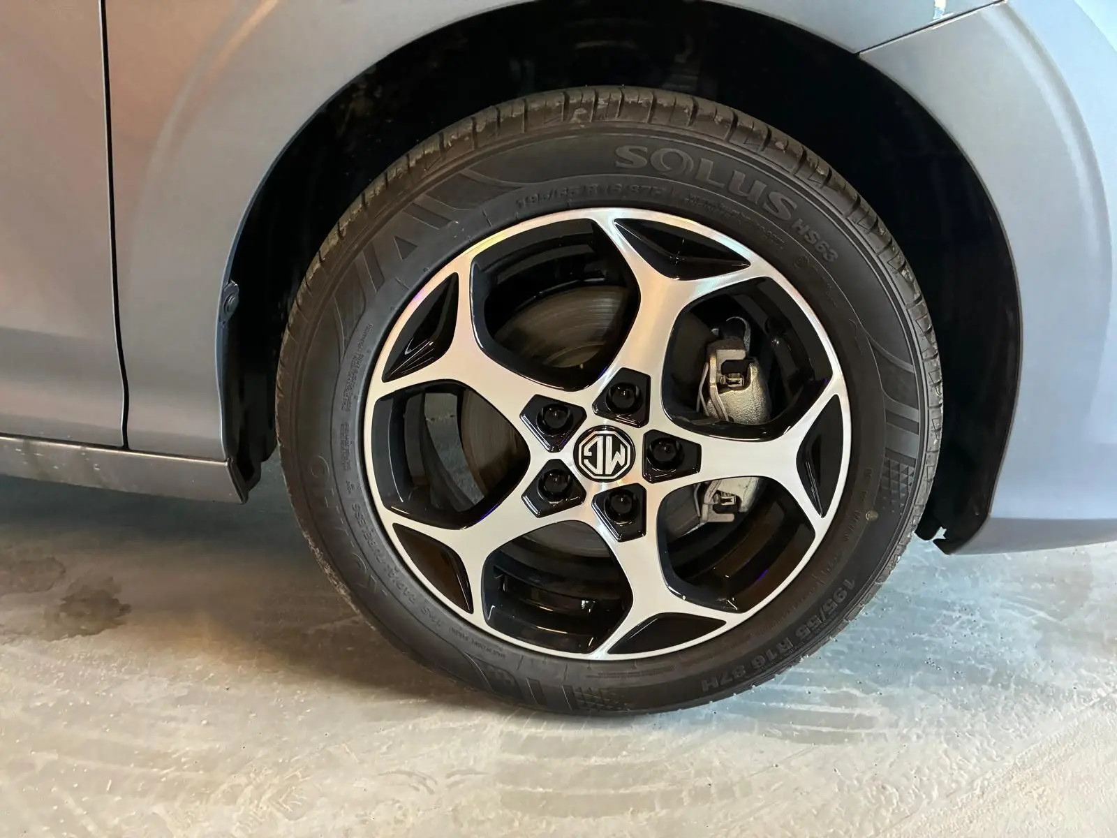 Gros plan sur la roue avant gauche noire du MG3 1.5 HYBRID+ 195 LUXURY avec jante alliage bicolore distinctive.