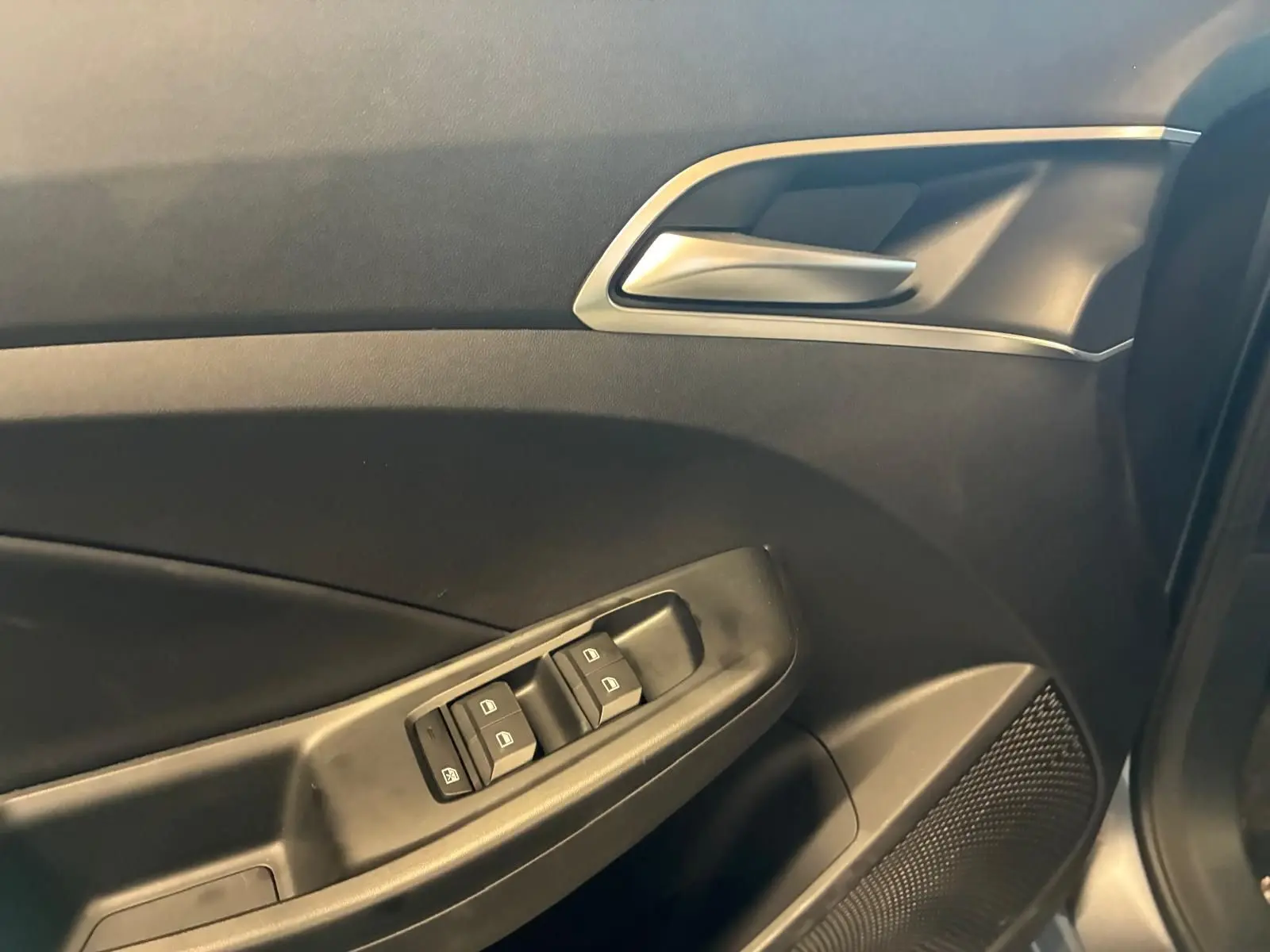 Détail de la porte côté gauche de la MG3 1.5 HYBRID+ 195 LUXURY noire, montrant les commandes des vitres et la poignée intérieure.