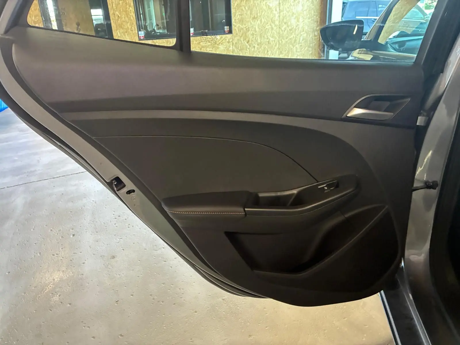 Gros plan sur la porte arrière gauche noire intérieure du MG3 1.5 HYBRID+ 195 LUXURY avec accoudoir et poignée intégrés.
