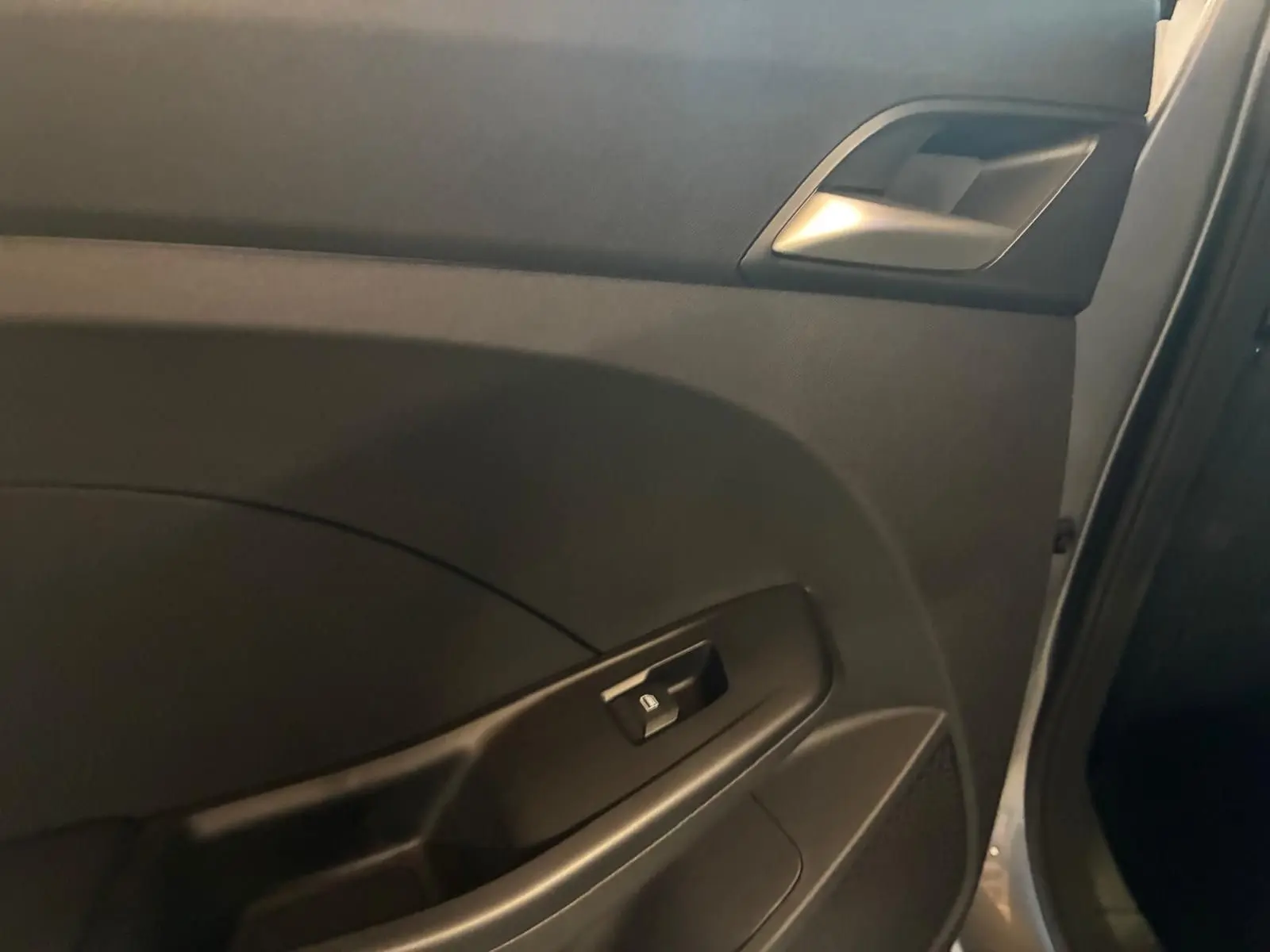 Détail de la porte intérieure côté droit du MG3 1.5 HYBRID+ 195 LUXURY noir, avec commande de vitre électrique.