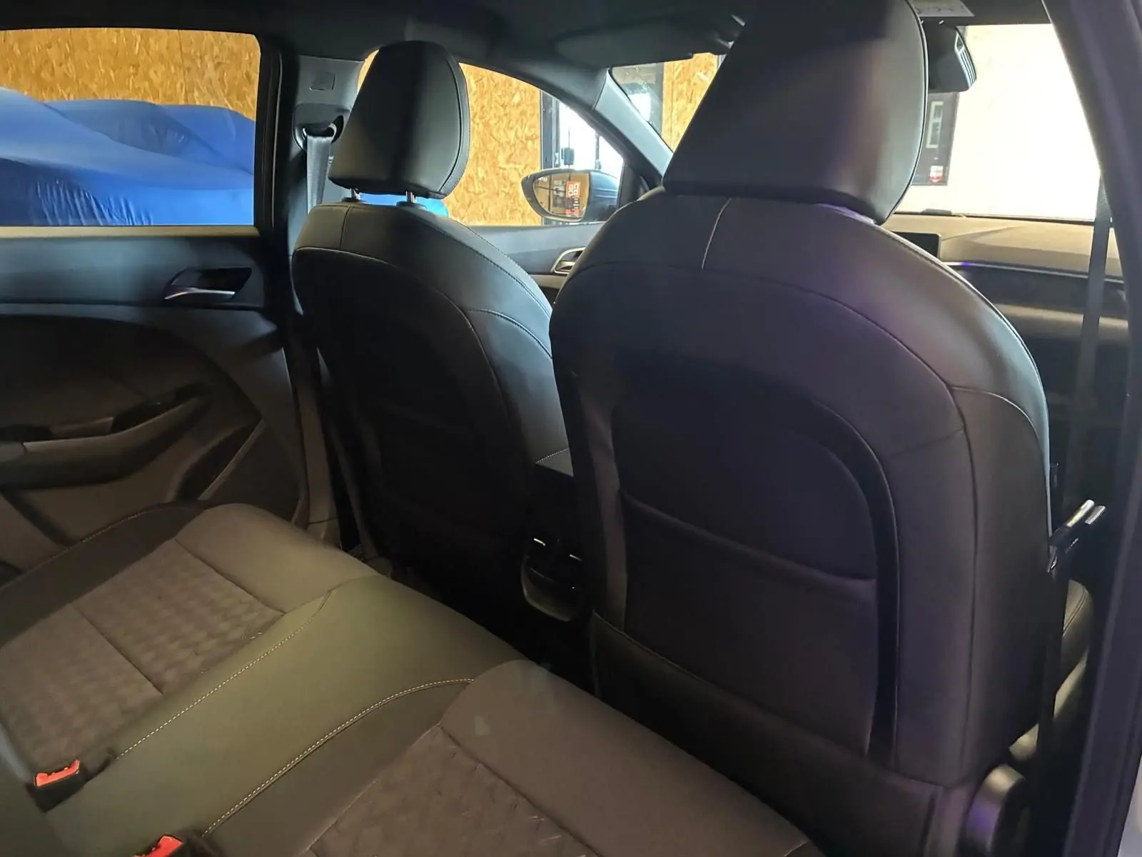 Vue intérieure arrière du MG3 1.5 HYBRID+ 195 LUXURY noir, sièges en cuir noir et détails modernes visibles.
