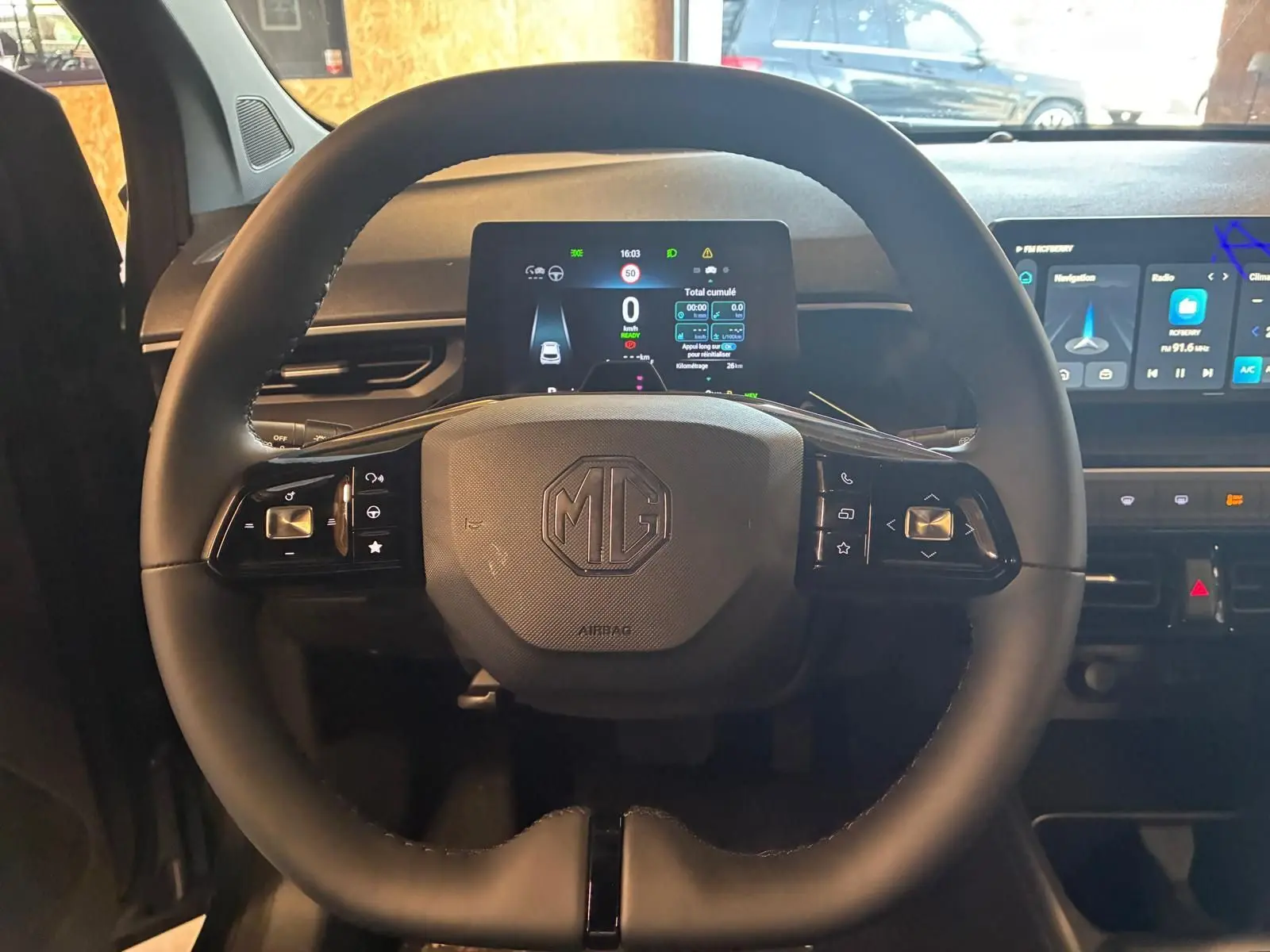 Vue rapprochée du volant noir de la MG3 1.5 HYBRID+ 195 LUXURY avec tableau de bord digital allumé.