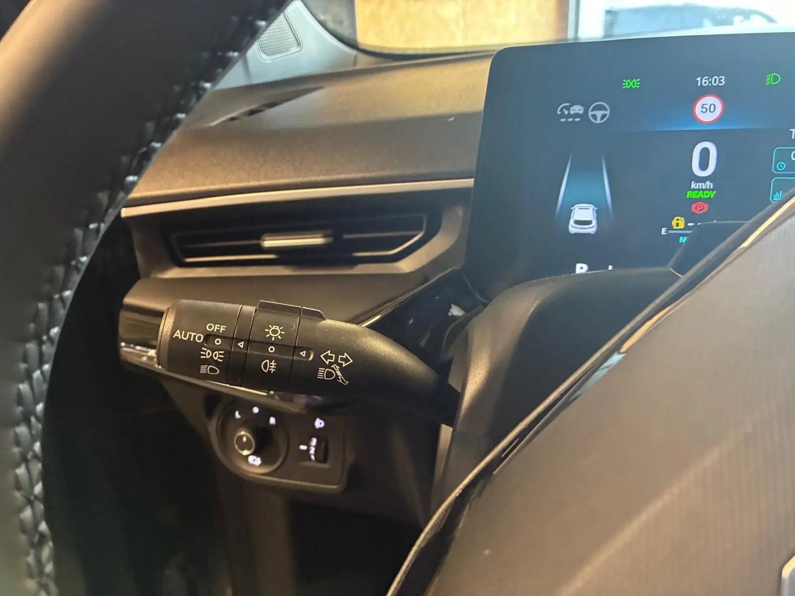 Vue rapprochée du combiné d'instruments et du commodo des phares d'un MG3 1.5 HYBRID+ 195 Luxury noir, intérieur moderne.