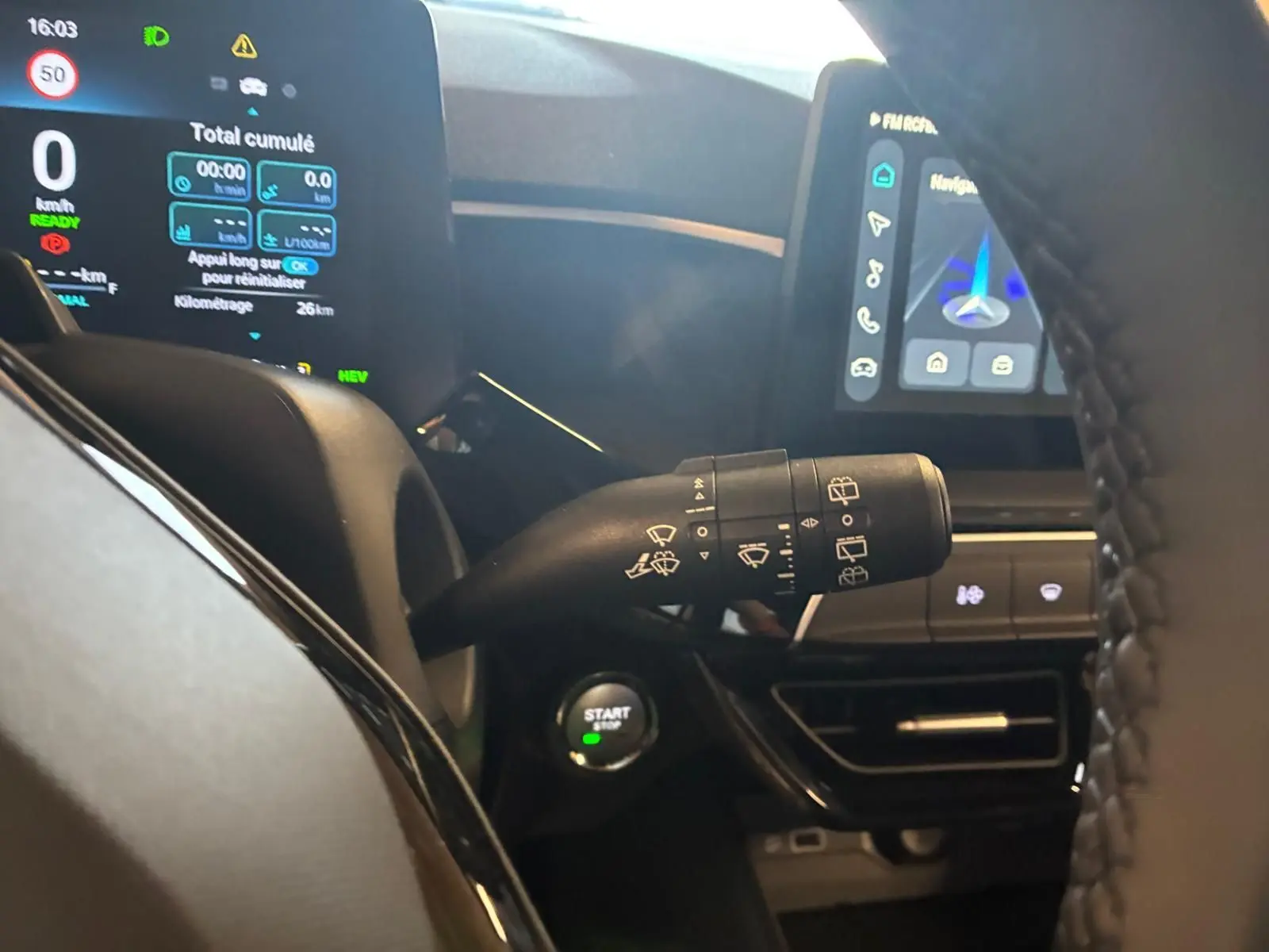 Vue rapprochée du commodo d’essuie-glace et du tableau de bord numérique d’une MG3 noire, version 1.5 Hybrid+ 195 Luxury.