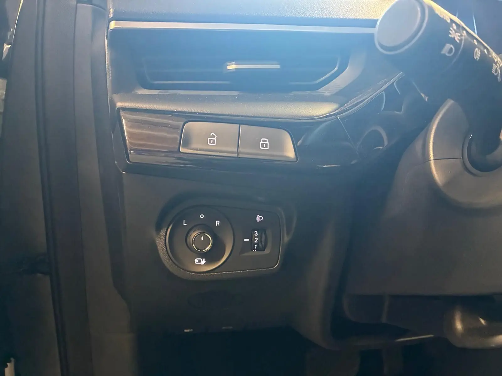 Détail du tableau de bord noir du MG3 1.5 HYBRID+ 195 LUXURY, avec commandes de réglage des rétroviseurs et verrouillage.