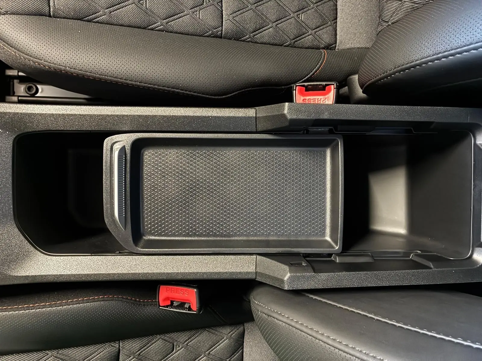 Vue plongeante sur la console centrale noire avec rangement ouvert et sièges en cuir noir du MG3 1.5 HYBRID+ 195 LUXURY.