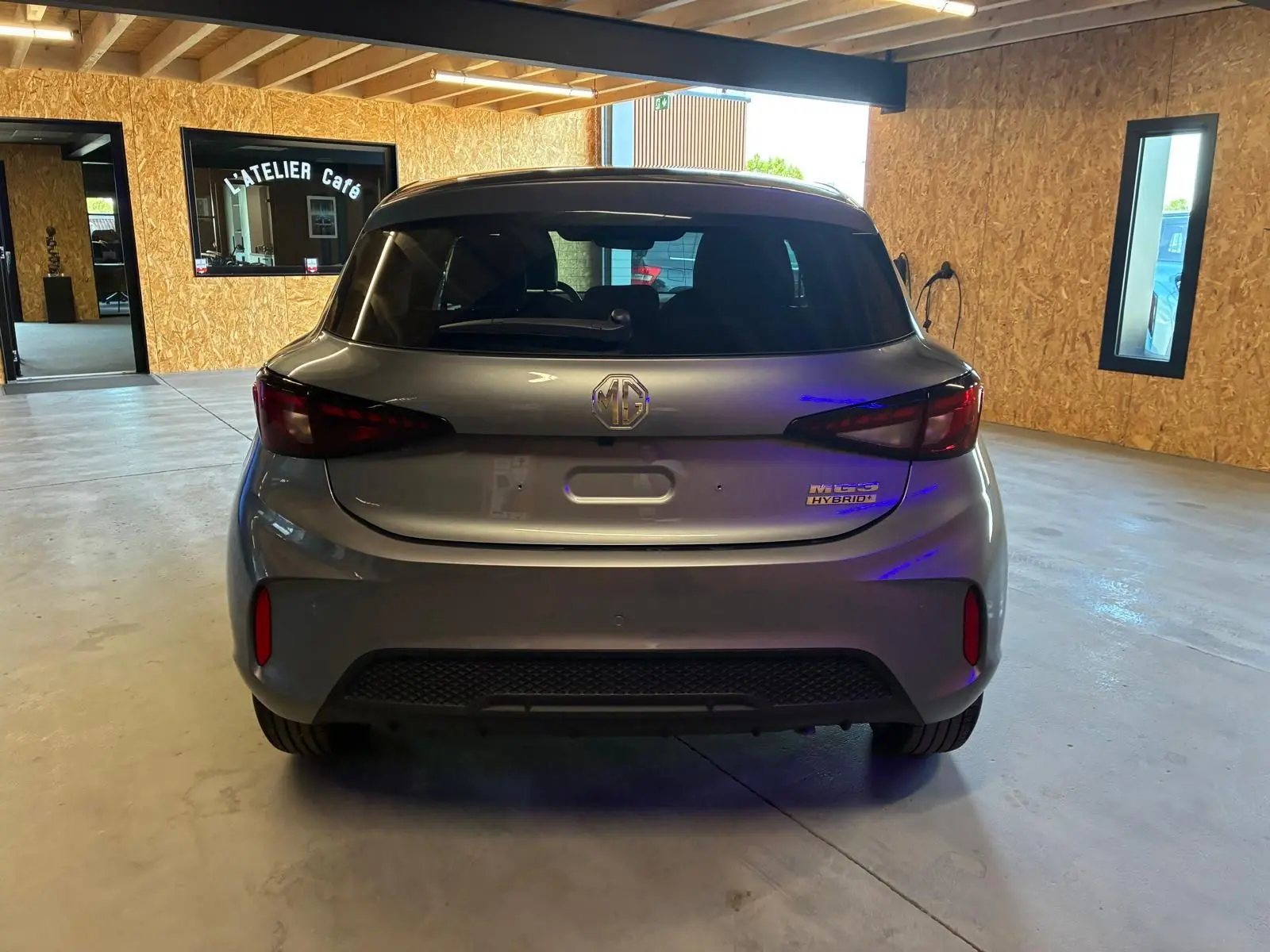 Vue arrière d'une MG3 1.5 HYBRID+ 195 LUXURY noire, avec feux arrière LED et badge hybride visible en intérieur.