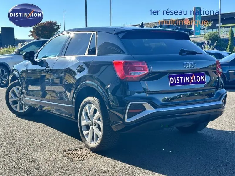Audi Q2 35 TFSI S line noir Mythic métallisé vue 3/4 arrière droit, avec jantes alliage et feux arrière LED.