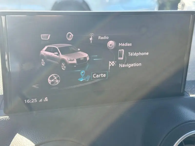Écran central affichant le menu multimédia et navigation avec une image 3D de l'Audi Q2 noir Mythic métallisé.