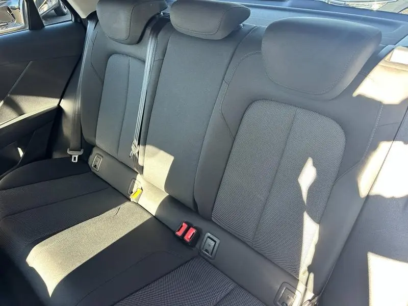 Vue intérieure des sièges arrière noirs de l'Audi Q2 35 TFSI S line 2023 avec ceintures et appuie-têtes visibles.