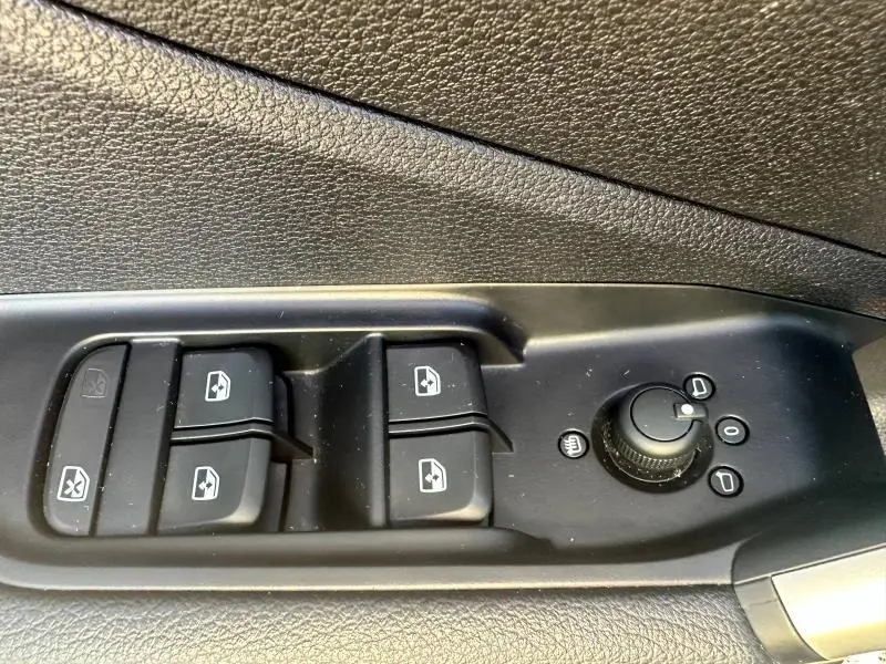 Gros plan sur les commandes de lève-vitres et rétroviseurs côté conducteur de l'Audi Q2 35 TFSI S line noir Mythic 2023.