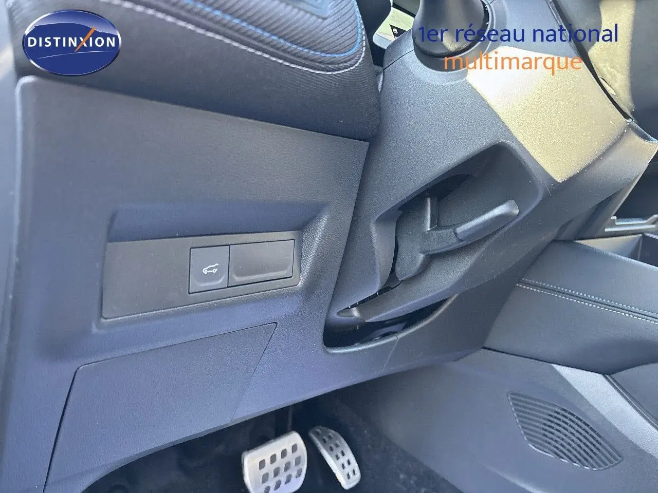 Détail intérieur côté conducteur montrant les pédales et un bouton de commande sur une Renault Symbioz noire étoile métal 2025.