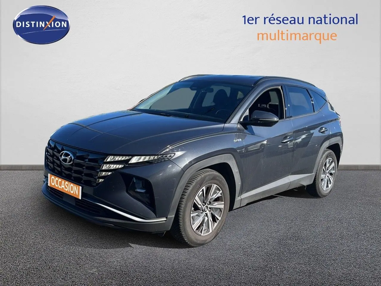 Hyundai Tucson gris foncé métal vu en 3/4 avant droit, avec calandre distinctive et jantes alliage modernes.