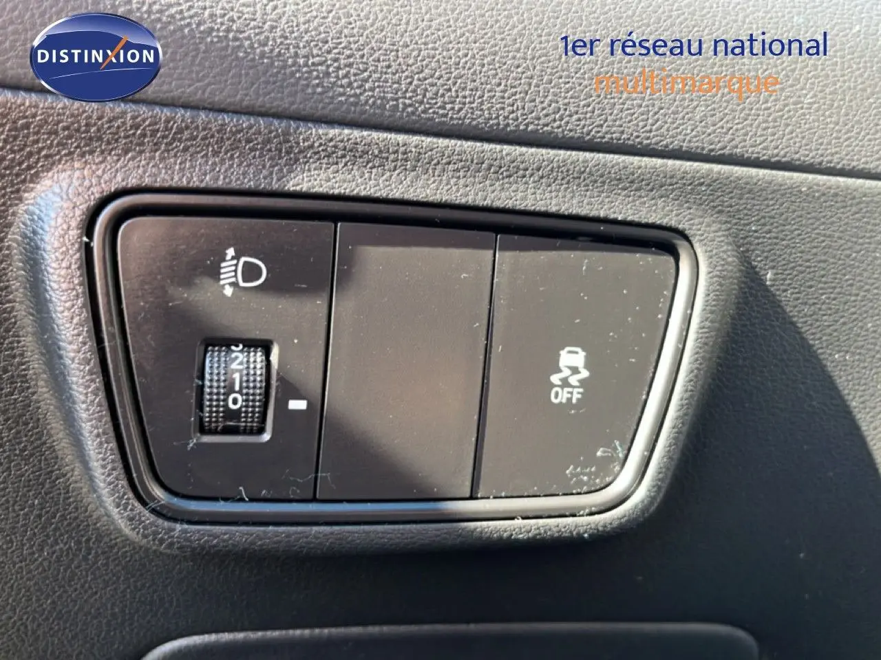 Gros plan sur les commandes de réglage des phares et désactivation de l'ESP dans un Hyundai Tucson gris foncé 2021.