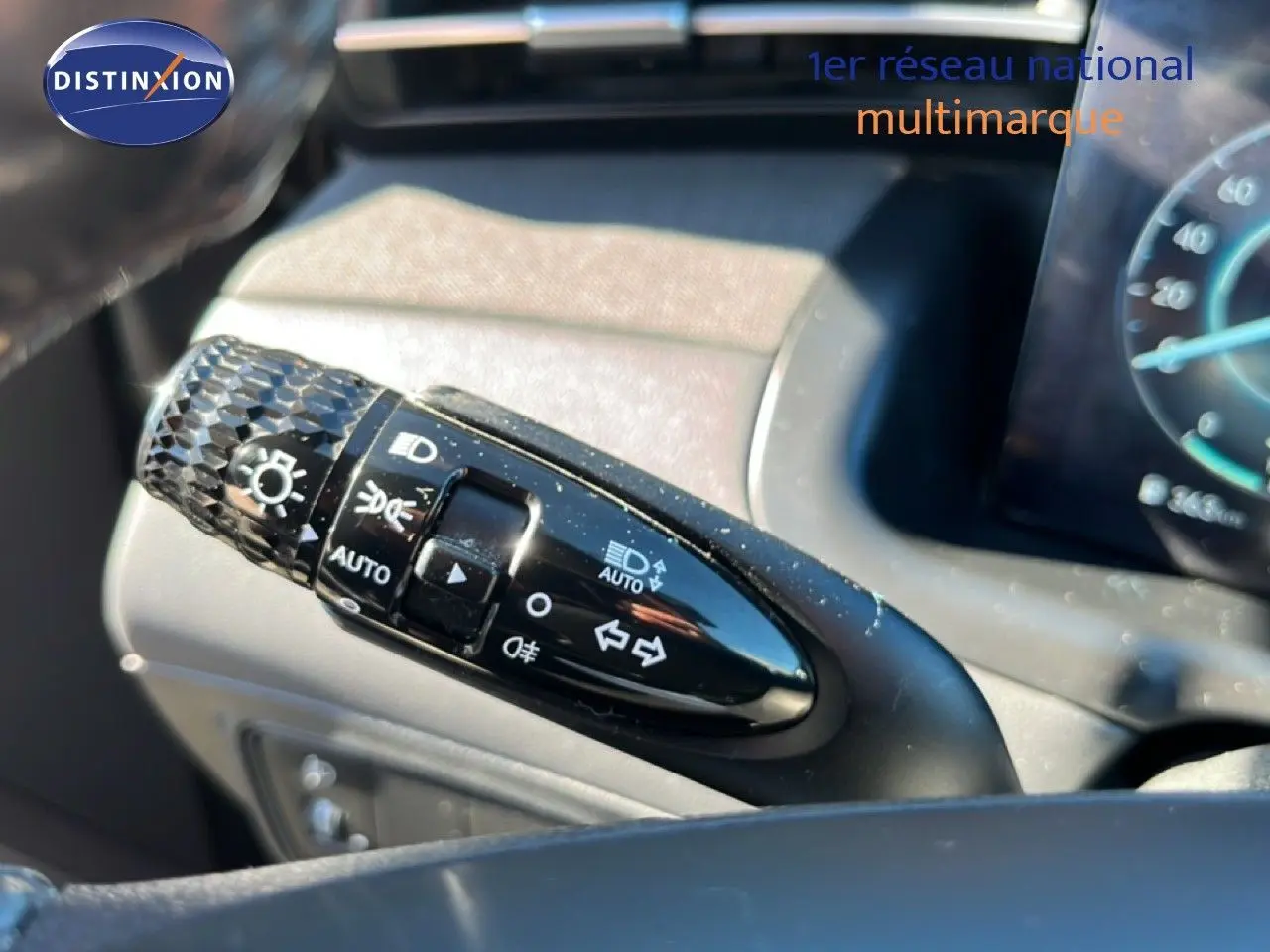Gros plan sur la commande des feux et clignotants du Hyundai Tucson gris foncé, intérieur tableau de bord visible.