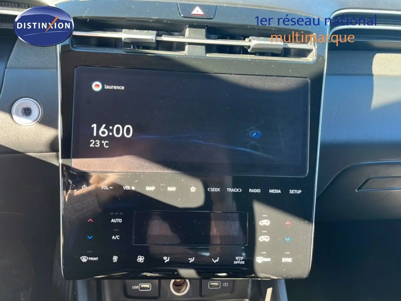 Vue rapprochée de la console centrale tactile du Hyundai Tucson gris foncé, affichant l'heure et la température.