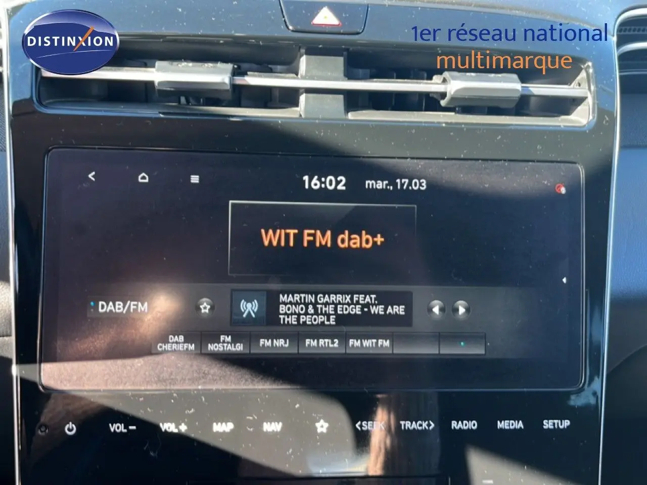 Vue rapprochée de l’écran tactile central du Hyundai Tucson gris foncé, affichant la radio DAB/FM WIT FM dab+.