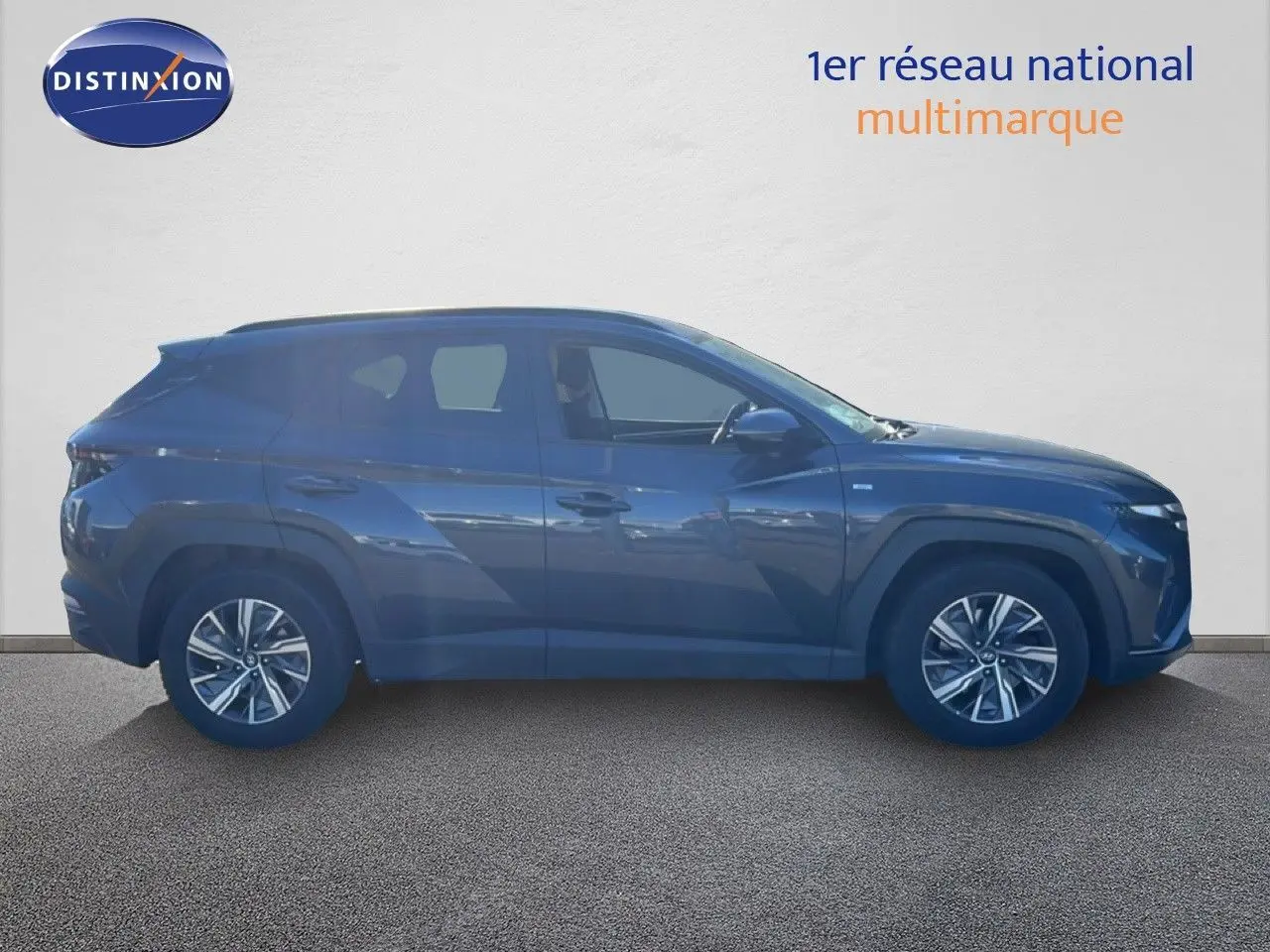 Vue de profil côté gauche du Hyundai Tucson gris foncé métal 2021, soulignant ses lignes modernes et ses jantes alliage.