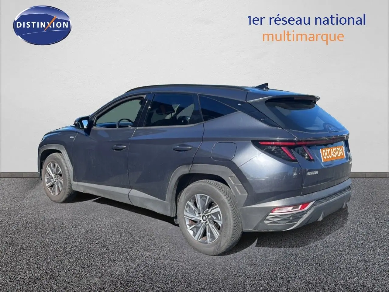 Vue 3/4 arrière gauche du Hyundai Tucson gris foncé métal avec feux arrière LED et jantes alliage.