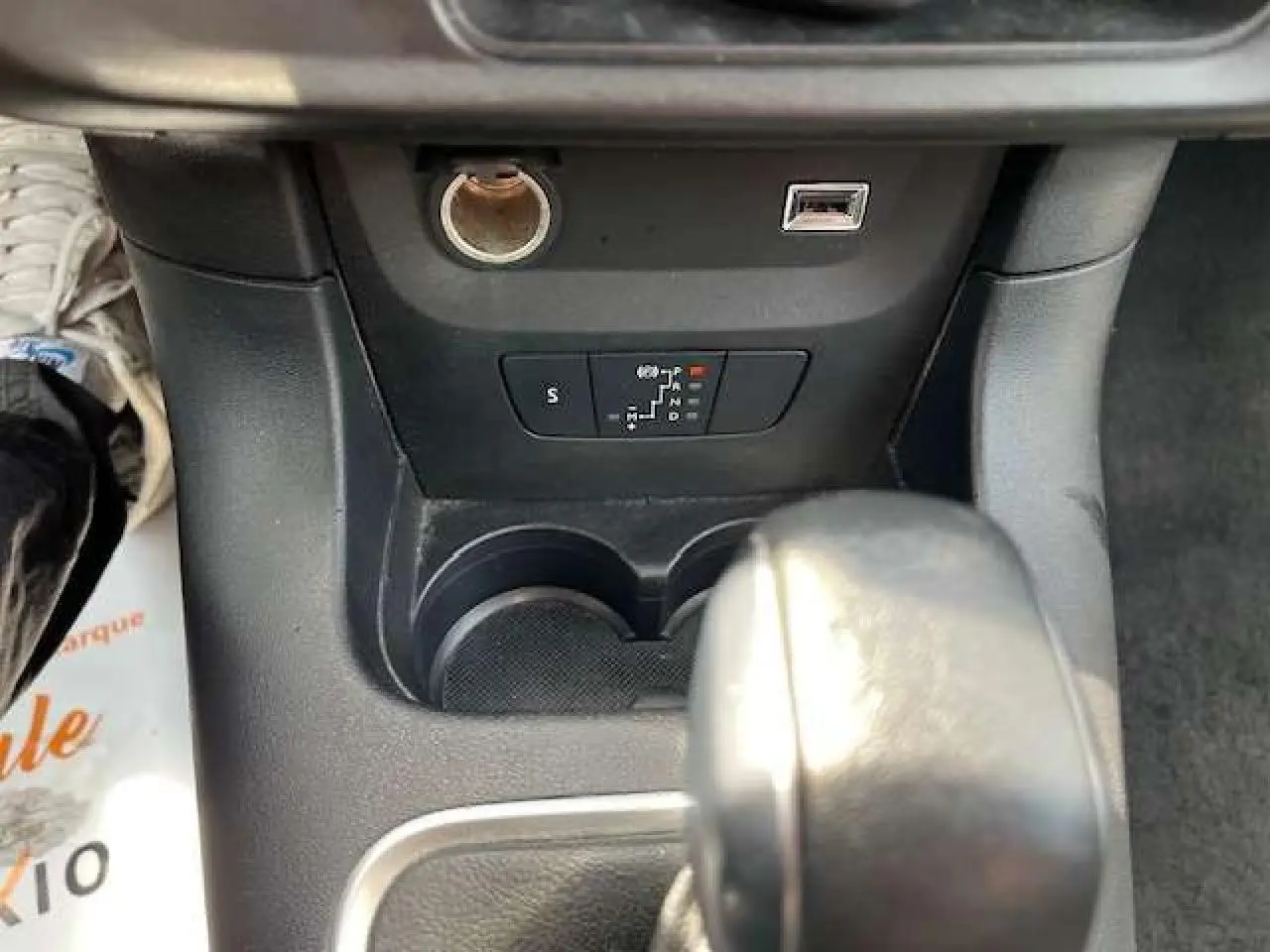 Gros plan sur la console centrale de la Citroën C3 2023, montrant le levier de boîte automatique et prises USB et 12V.