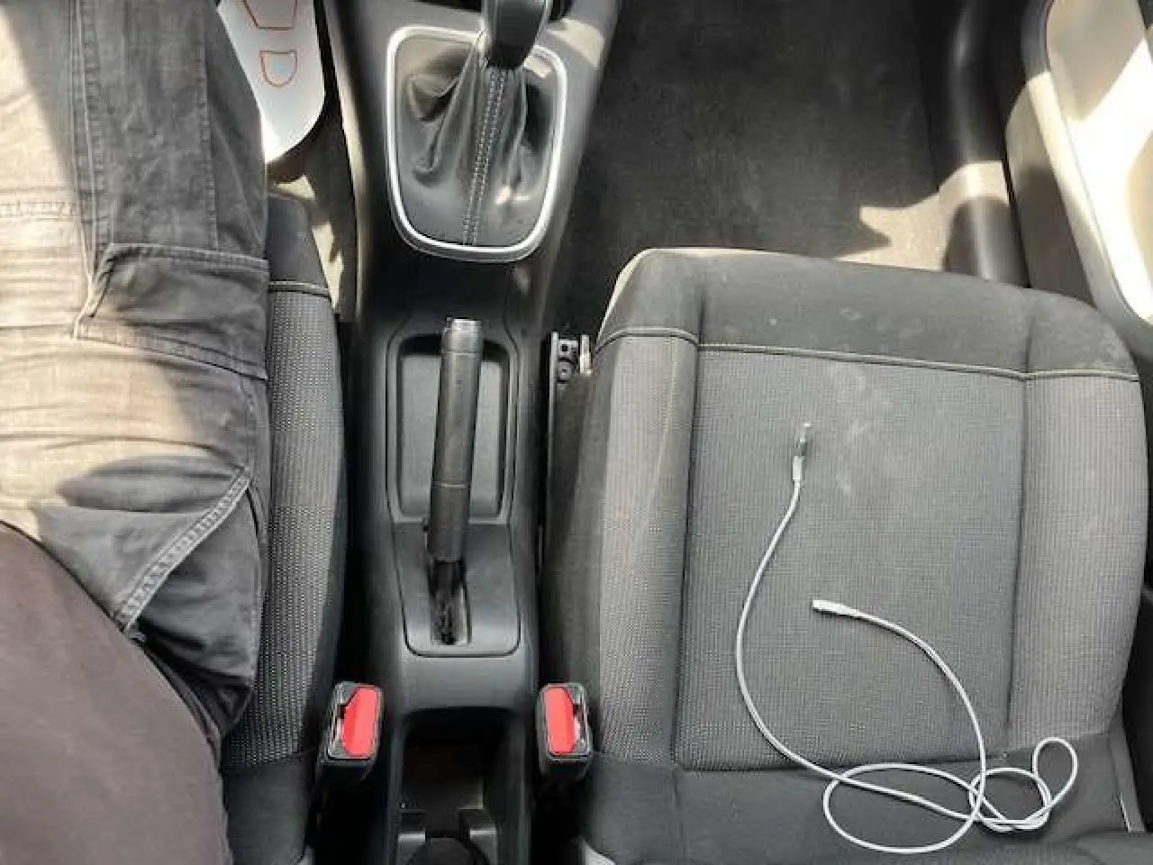 Vue plongeante sur la console centrale et les sièges avant noirs d'une Citroën C3 2023 avec levier de vitesse automatique.