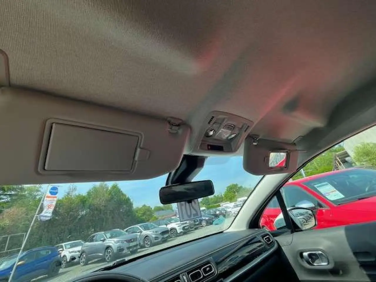 Vue intérieure côté passager avant de la Citroën C3 2023, toit blanc et tableau de bord noir brillant visible.