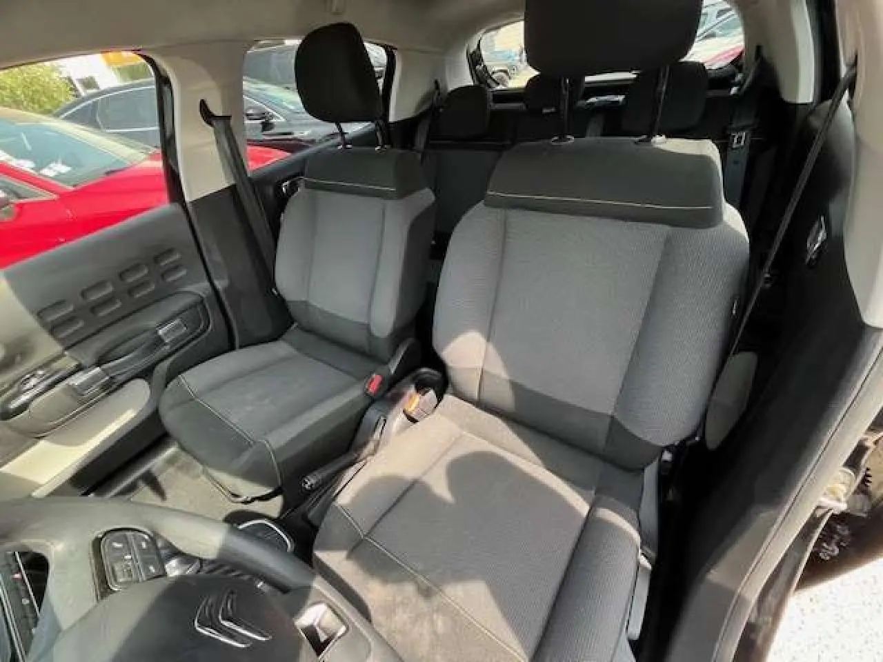 Vue intérieure de la Citroën C3 2023 montrant les sièges avant gris et noir avec détails de la portière côté gauche.