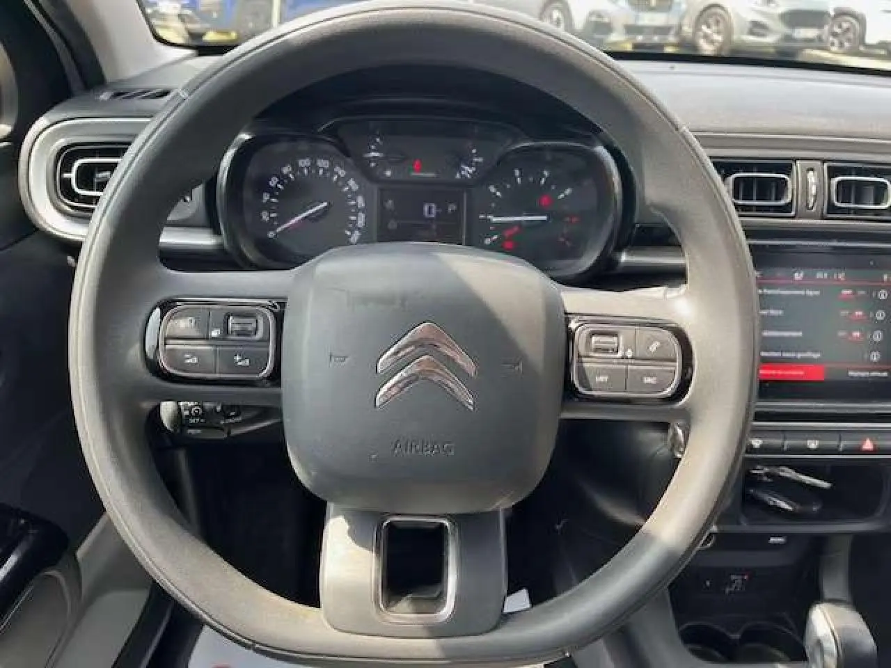Vue intérieure centrée sur le volant noir de la Citroën C3 2023 avec tableau de bord et écran tactile visibles.