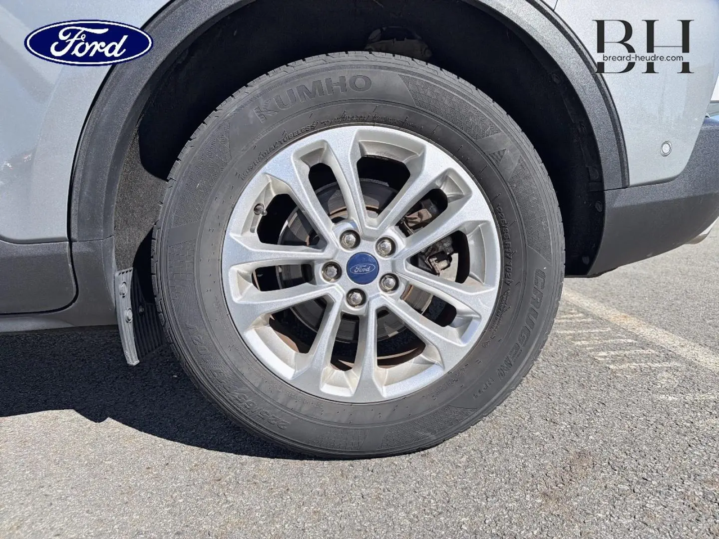 Gros plan sur la roue avant gauche du Ford Kuga gris Solar Métallisé, mettant en valeur la jante alu et le logo Ford central.