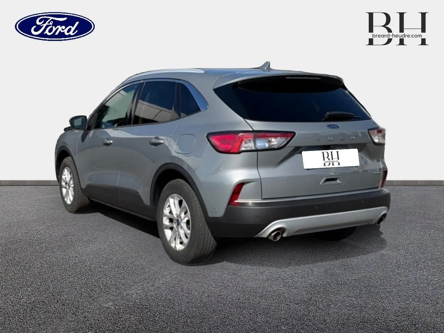 Ford Kuga gris Solar métallisé vu en 3/4 arrière droit avec vitres arrière surteintées et double sortie d’échappement.
