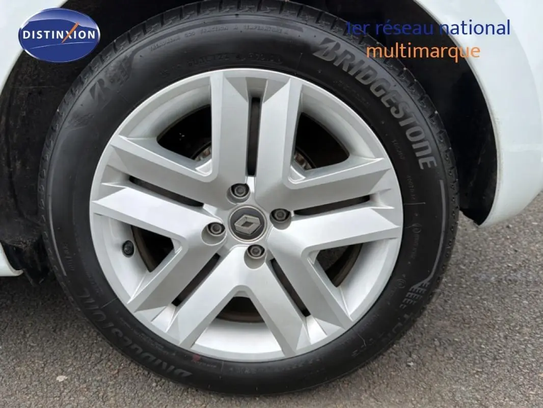 Gros plan sur la roue avant droite d'une Renault Clio blanche, mettant en valeur la jante alliage et le pneu Bridgestone.
