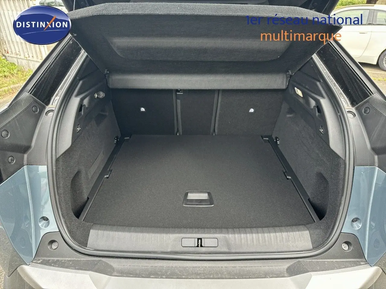Coffre ouvert du Peugeot 3008 Hybrid bleu Ingaro métal avec intérieur noir, vue arrière montrant l'espace de chargement.