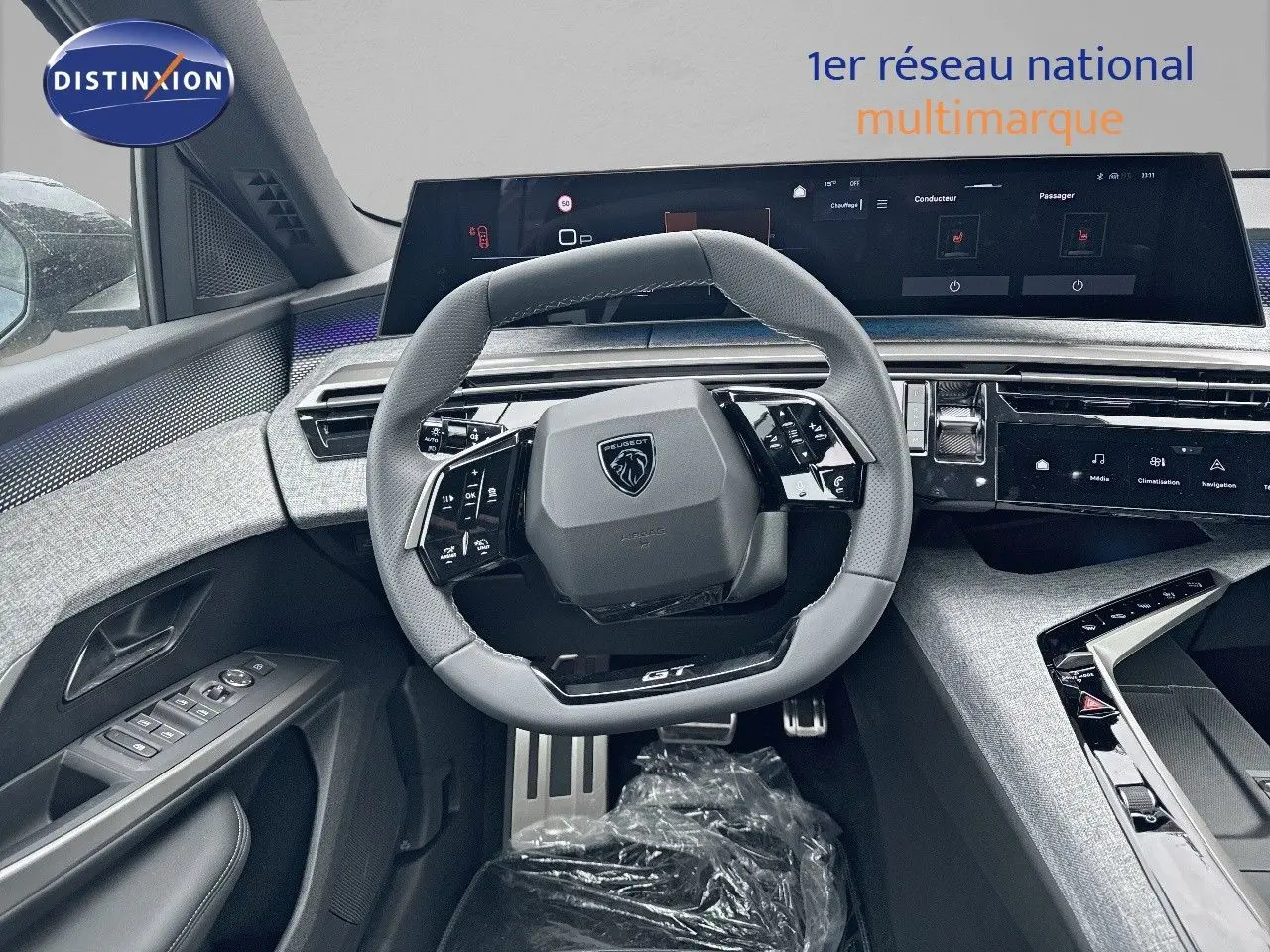 Vue intérieure centrée sur le volant gris du Peugeot 3008 Hybrid 136ch GT avec tableau de bord numérique moderne.