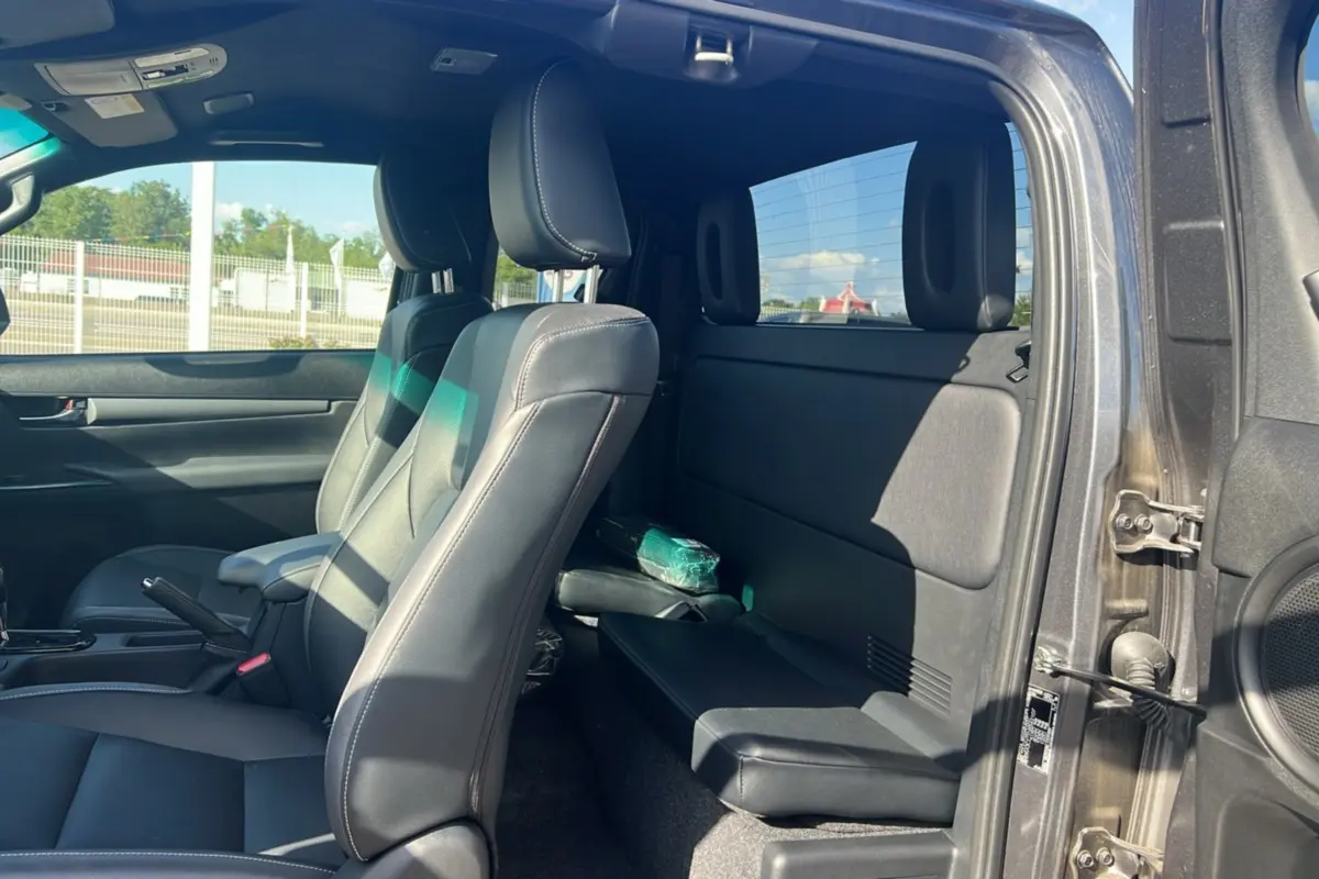 Intérieur du Toyota Hilux 2025 gris atlas, vue côté droit sur les sièges avant en cuir et banquette arrière compacte.