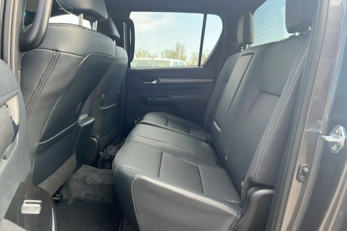 Vue intérieure sur la banquette arrière en cuir noir du Toyota Hilux 2025 gris atlas, côté droit ouvert.