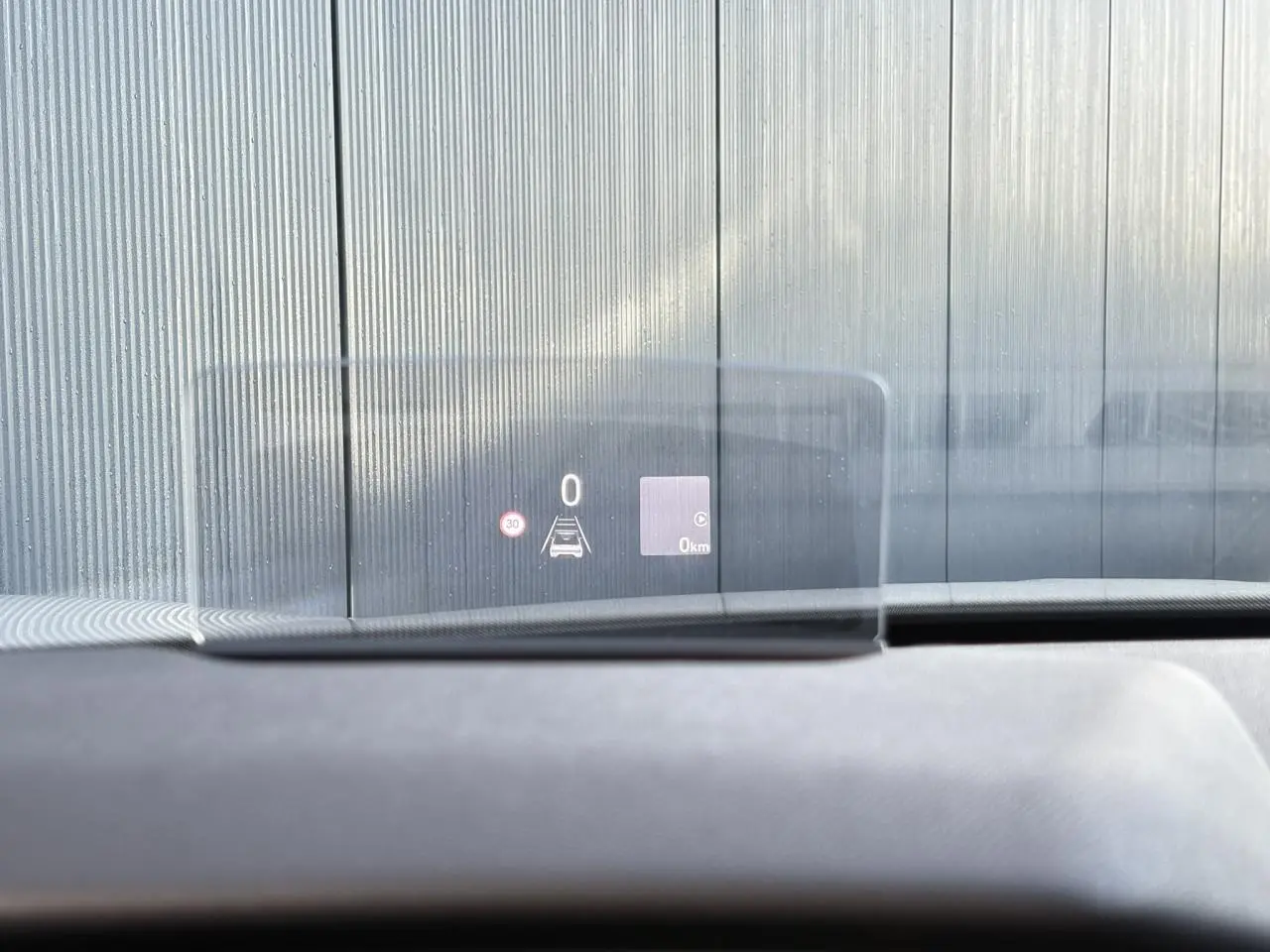 Affichage tête haute transparent du tableau de bord d'une DS3 2024, vue intérieure avant, avec indication de vitesse et alertes.