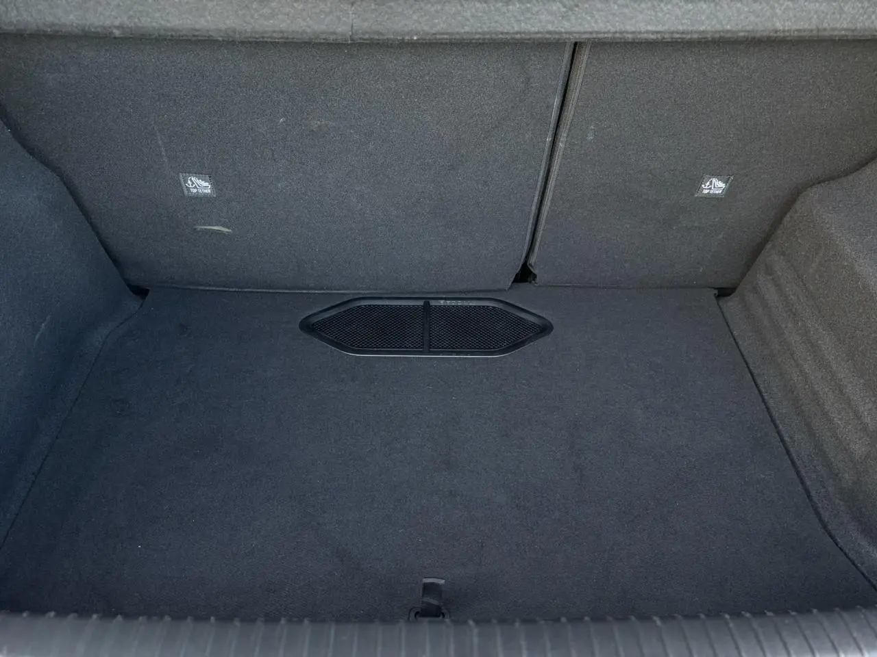 Vue intérieure du coffre spacieux et tapissé en tissu gris foncé du DS3 2024 bi-ton gris Artense et noir.