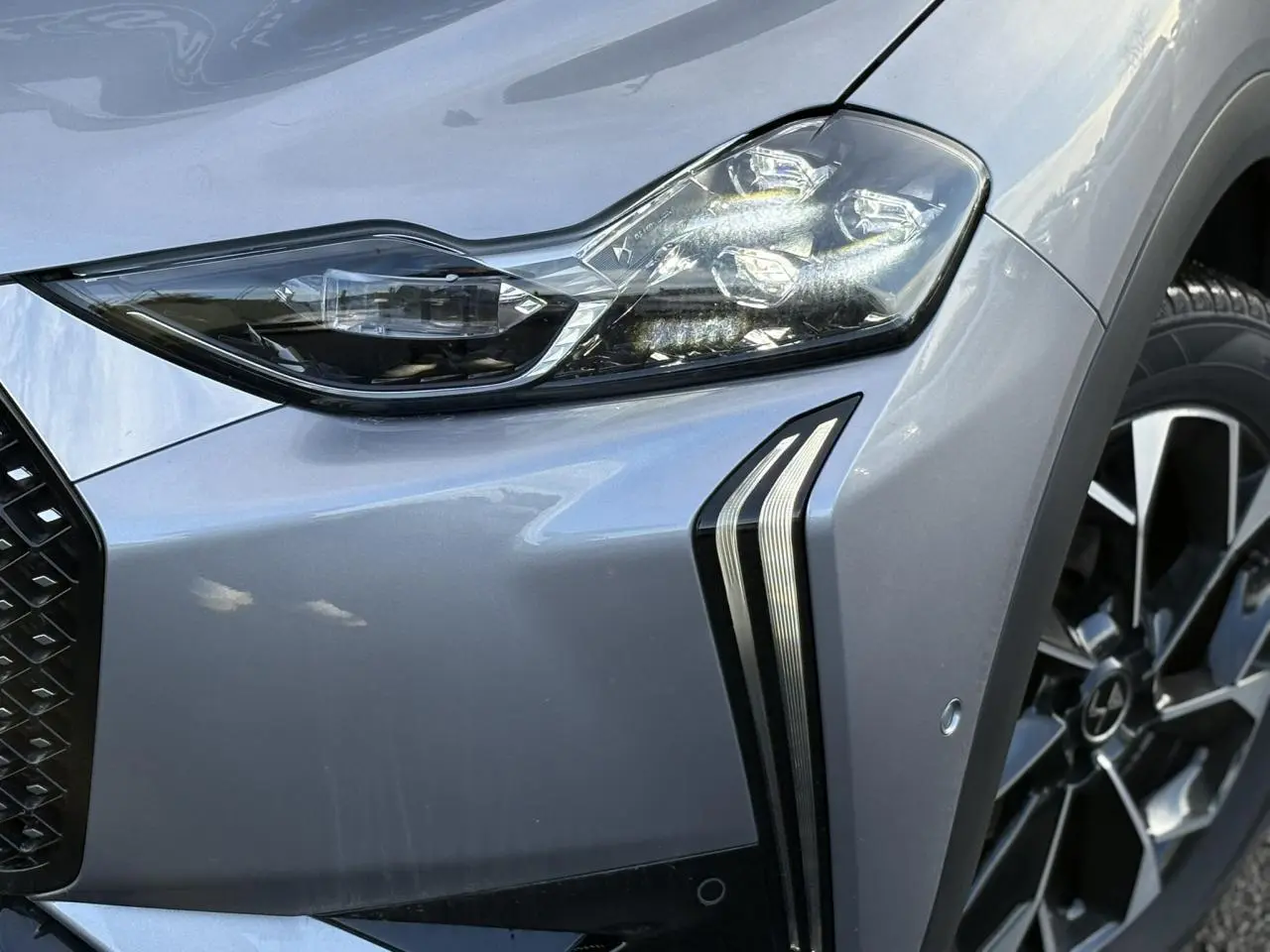 Vue intérieure côté conducteur de la DS3 2024, sièges cuir noir avec console centrale et volant cuir fleur.