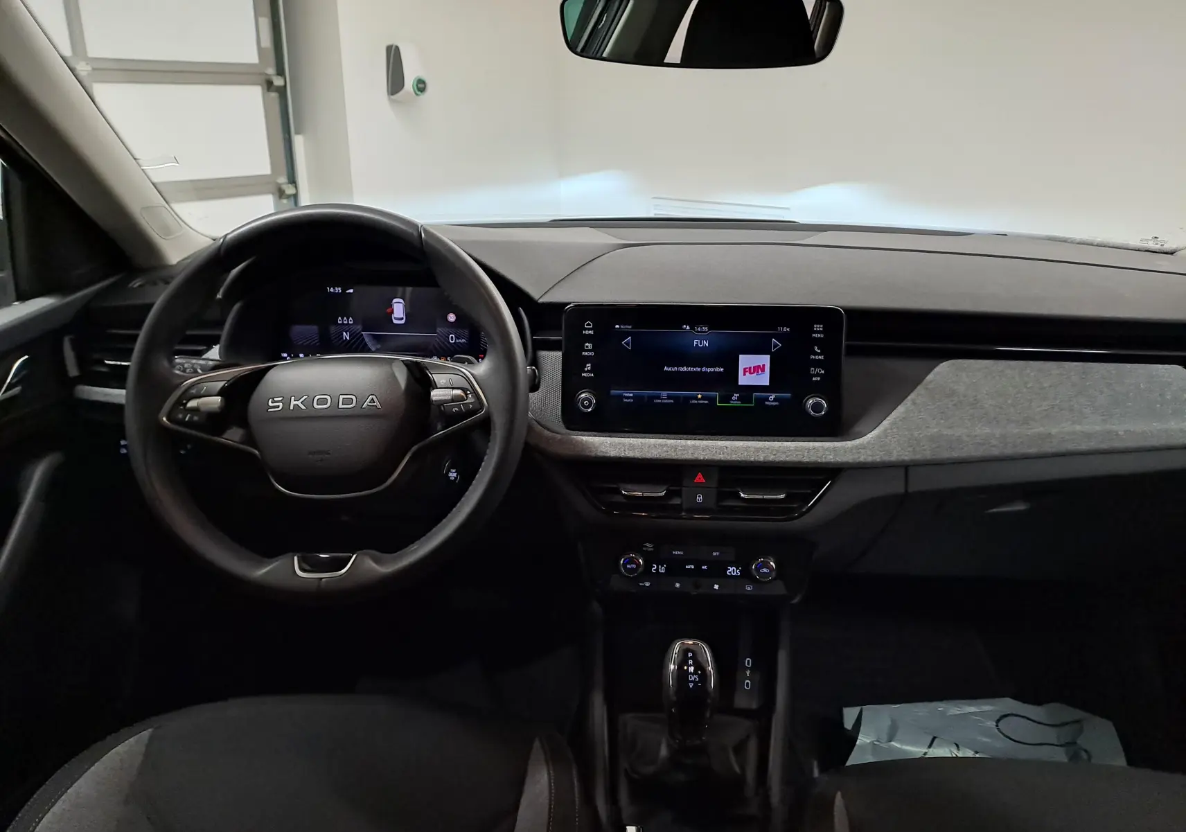 Vue intérieure frontale du tableau de bord du Skoda Kamiq gris graphite, avec volant multifonction et écran tactile central.