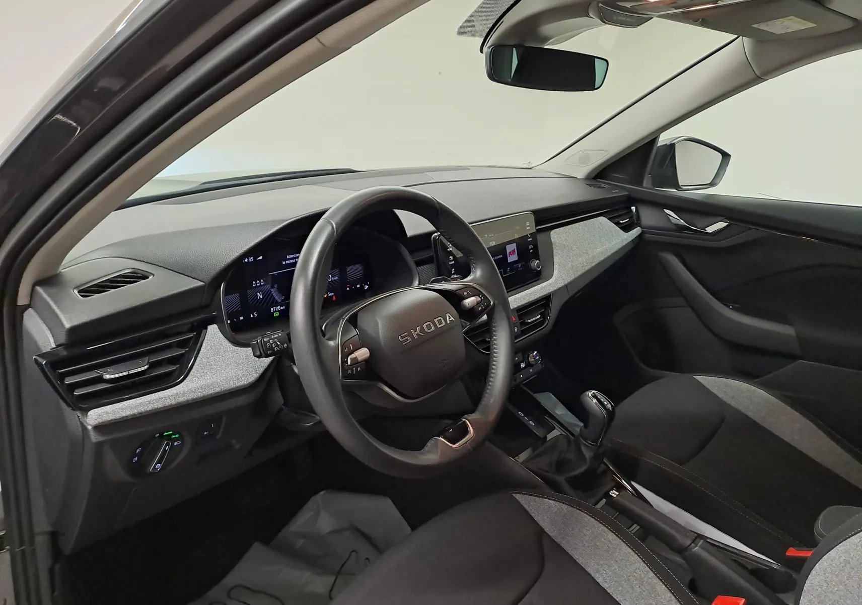 Intérieur avant droit du Skoda Kamiq gris graphite 2025, volant multifonction et tableau de bord digital.
