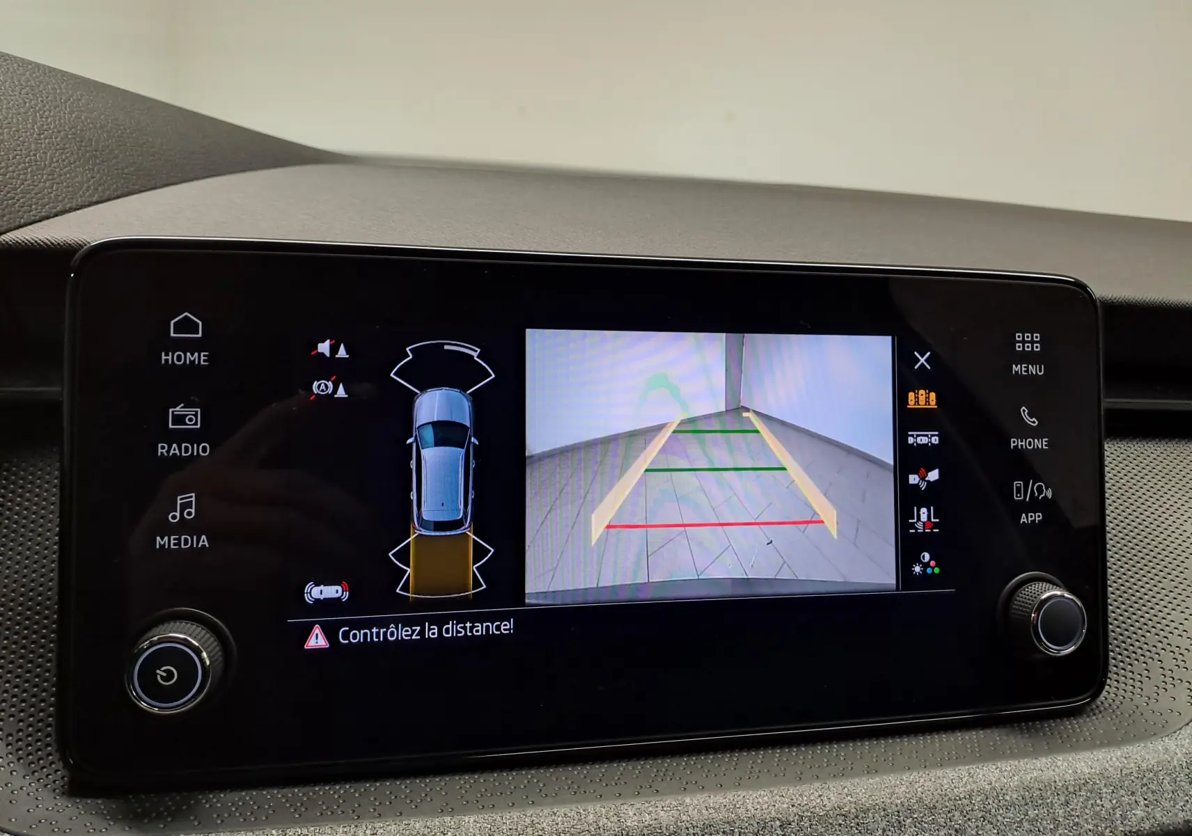 Écran tactile intérieur affichant la caméra de recul et l’aide au stationnement du Skoda Kamiq gris graphite, version 2025.