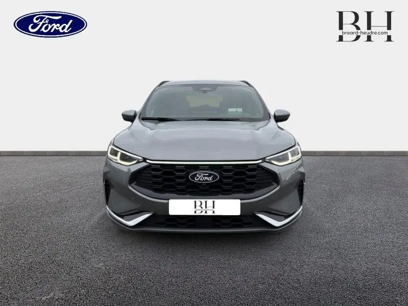 Vue avant du Ford Kuga 2024 gris Solar métallisé avec calandre noire hexagonale et phares LED allumés.