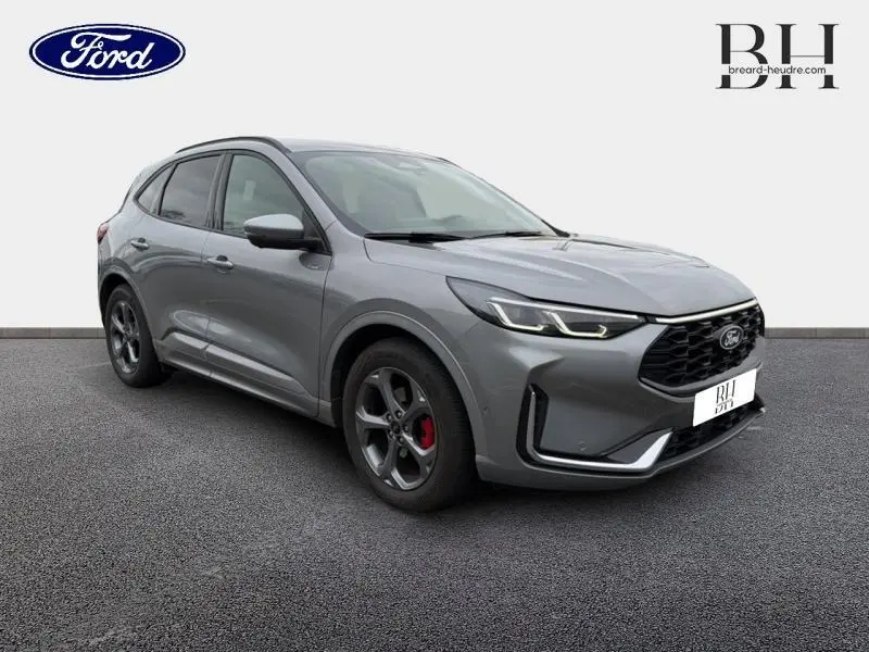 Ford Kuga 2024 gris Solar métallisé en vue 3/4 avant droit avec jantes alu et étriers rouges visibles.