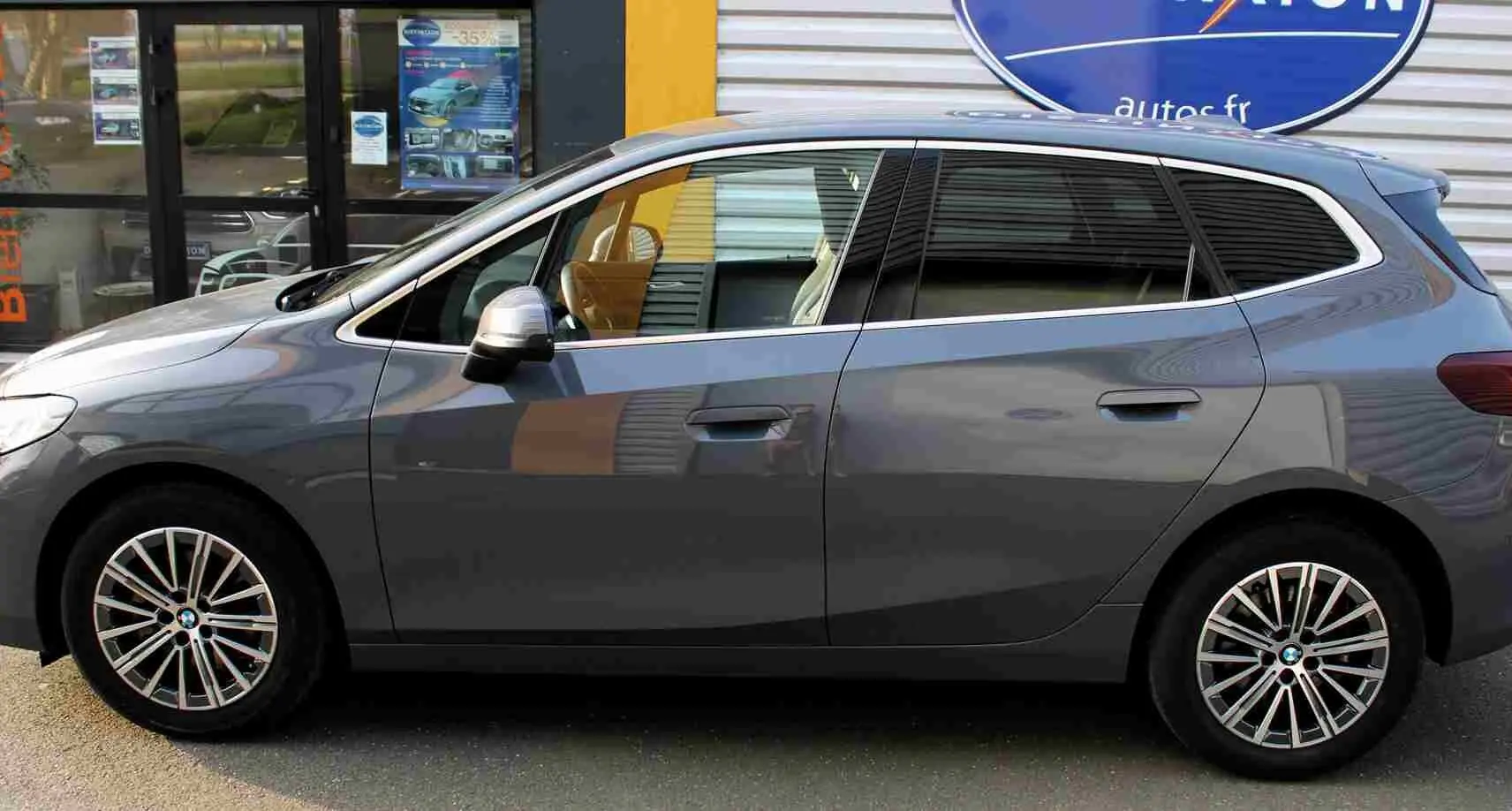 Vue de profil côté gauche d'une BMW Série 2 Active Tourer gris Nardo métallisé avec jantes alliage 17 pouces.