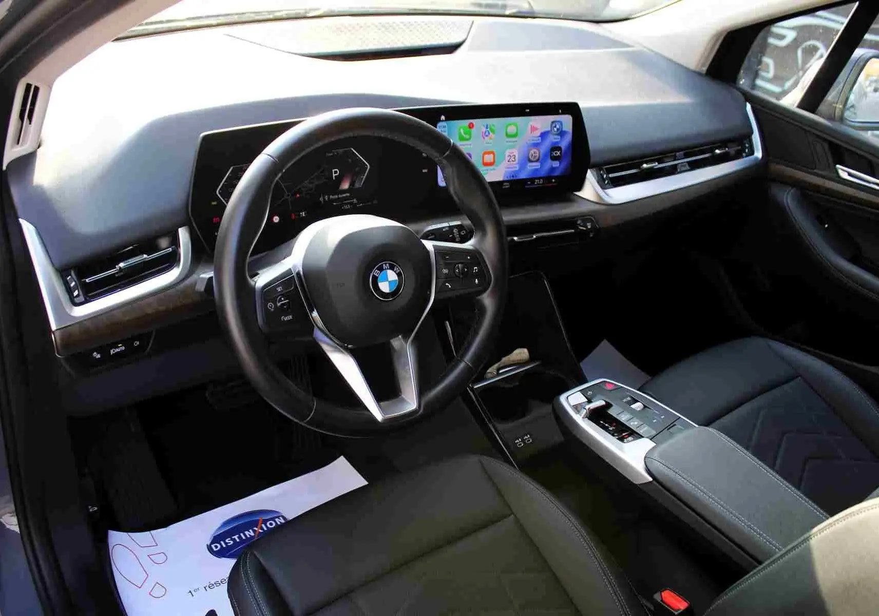 Vue intérieure côté conducteur de la BMW Série 2 Active Tourer 2023 avec tableau de bord numérique et volant cuir noir.