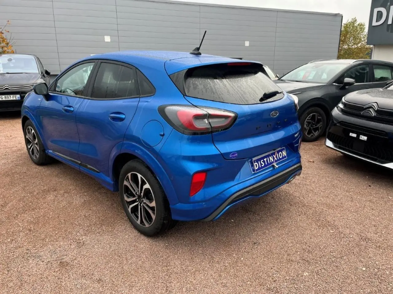 Vue 3/4 arrière droite d'un Ford Puma bleu métallisé avec jantes alliage noires et vitres arrière surteintées.
