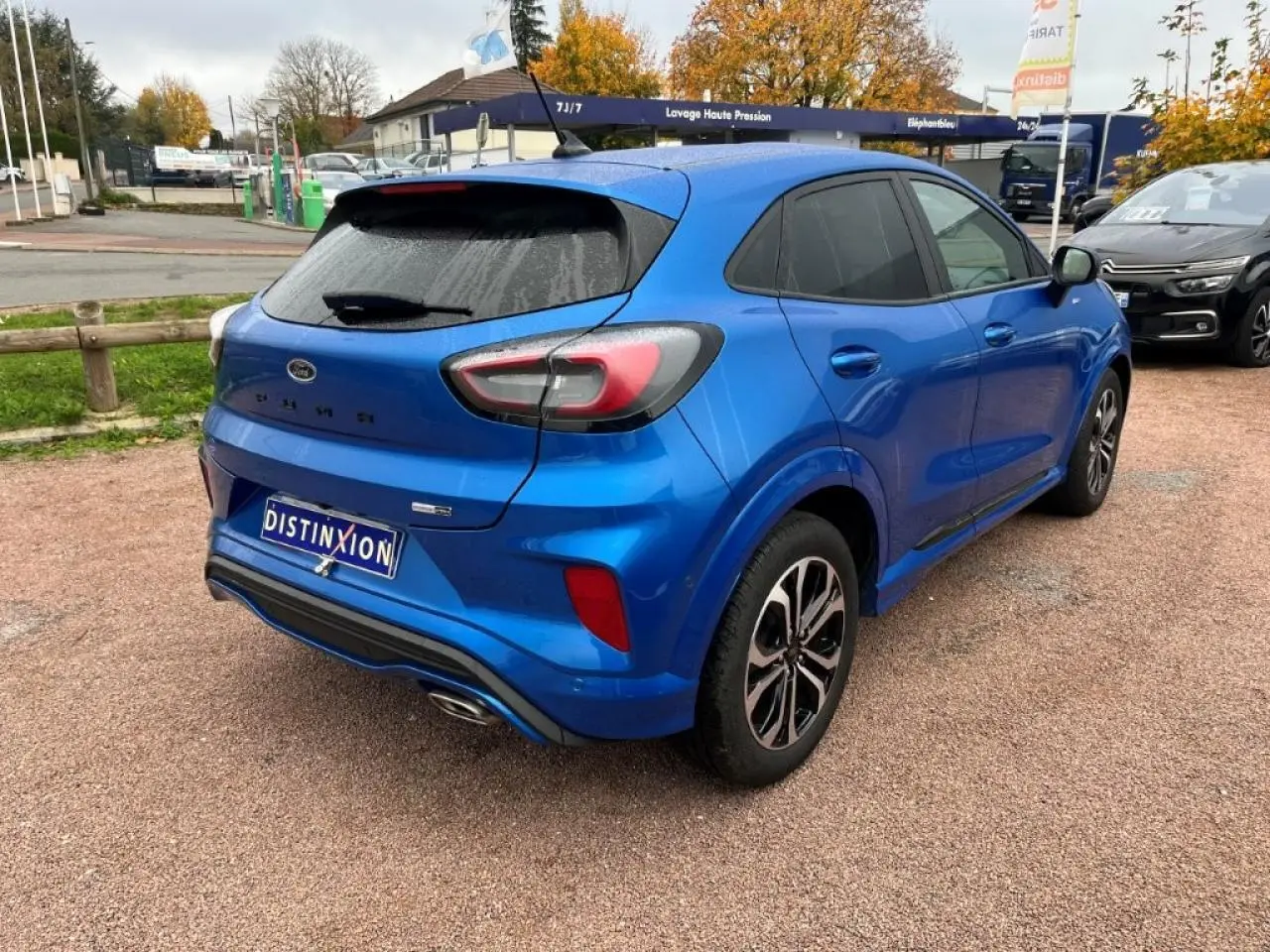 Vue 3/4 arrière droite d'un Ford Puma bleu métallisé avec vitres arrière surteintées et jantes alliage noires.