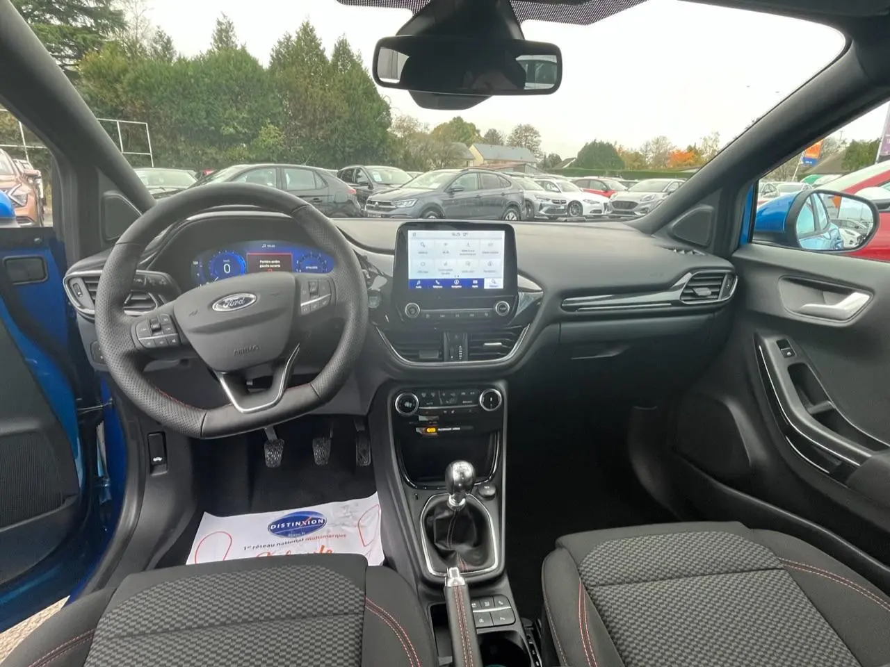 Vue intérieure avant du Ford Puma bleu 2022, montrant le tableau de bord, volant multifonction et levier de vitesse manuel.