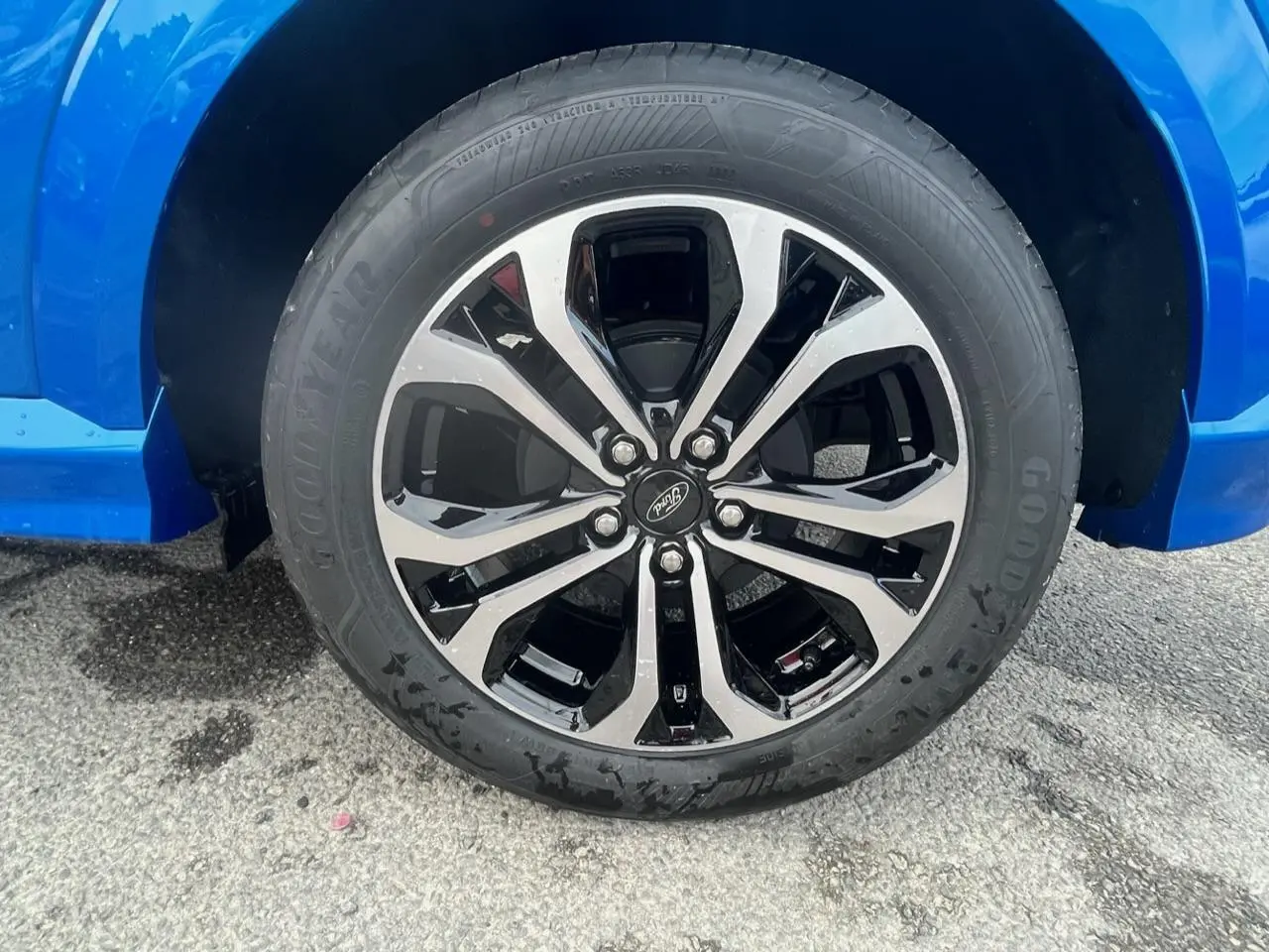 Gros plan sur la jante alliage 17 pouces bicolore noir et argent du côté gauche d’un Ford Puma bleu métallisé.